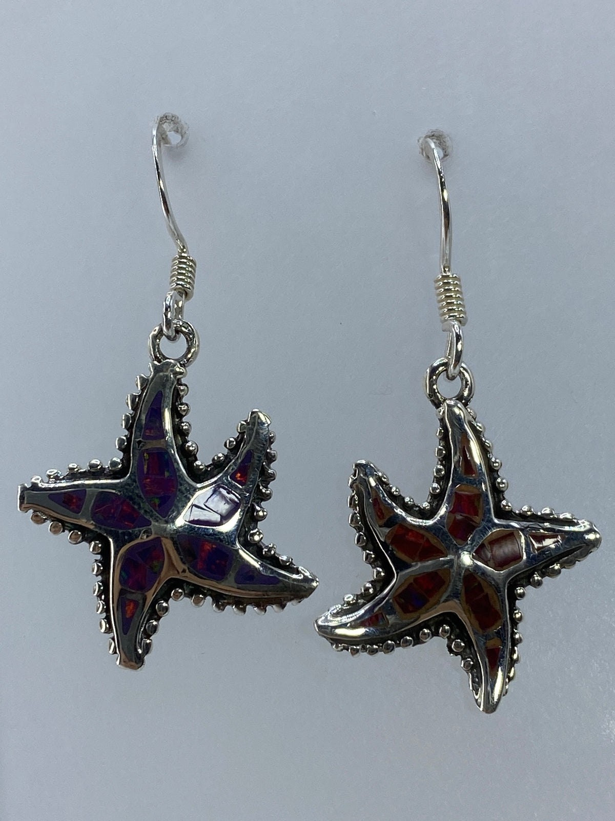Close-up of fire opal stone showing red, orange and yellow fire colors in starfish setting