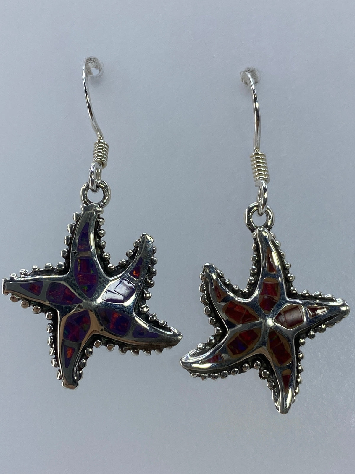 Starfish earrings on woman's ear showing full 3.9 cm length with hook closure