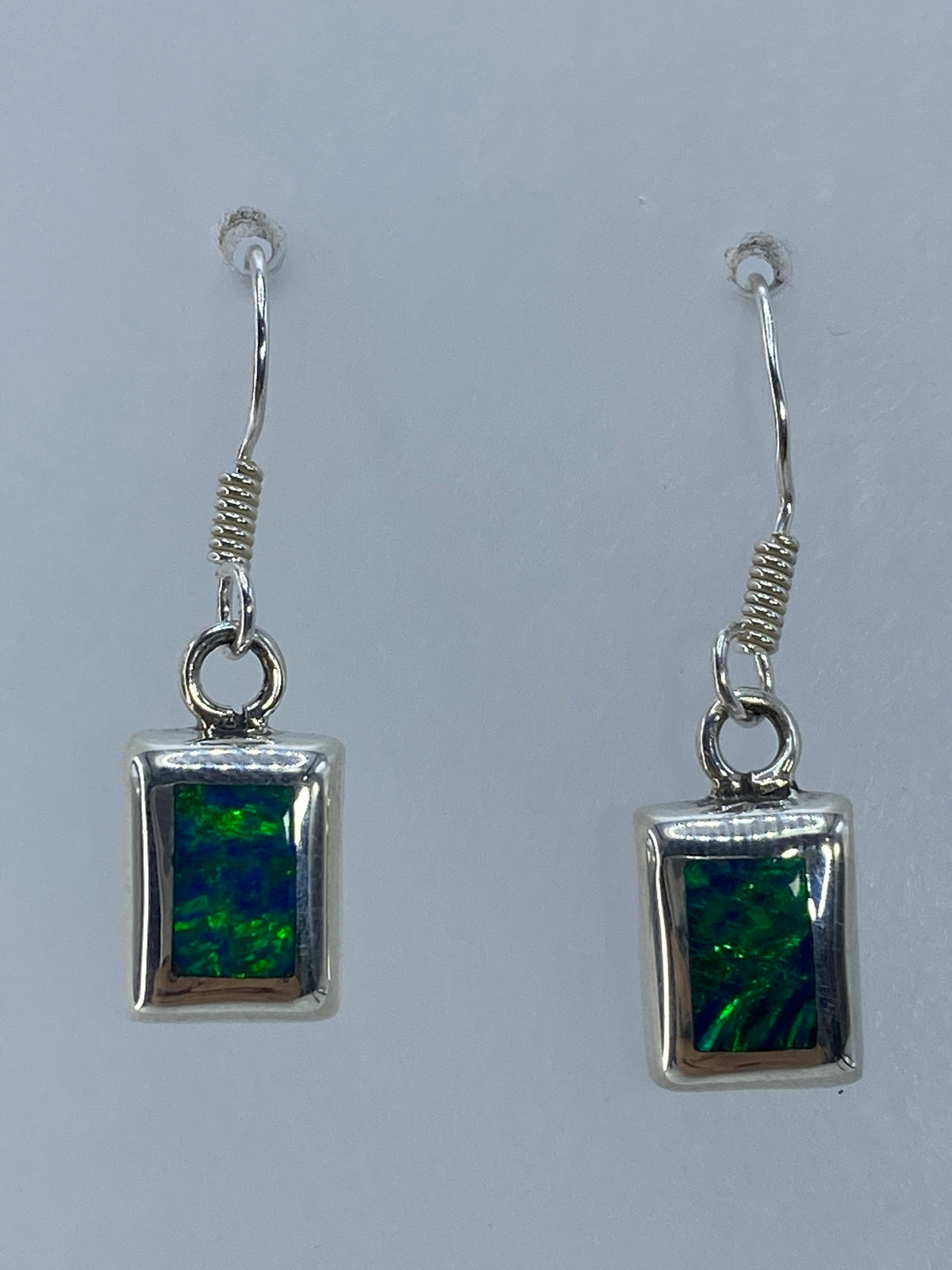 Par de aretes de plata con ópalo de fuego verde en marco cuadrado — vista frontal