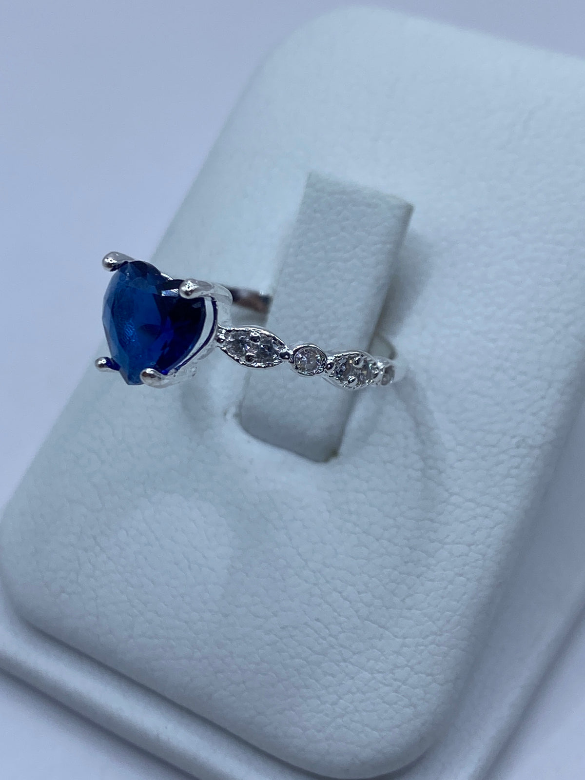 Anillo en la mano de una mujer, luciendo el brillo de la circonia azul