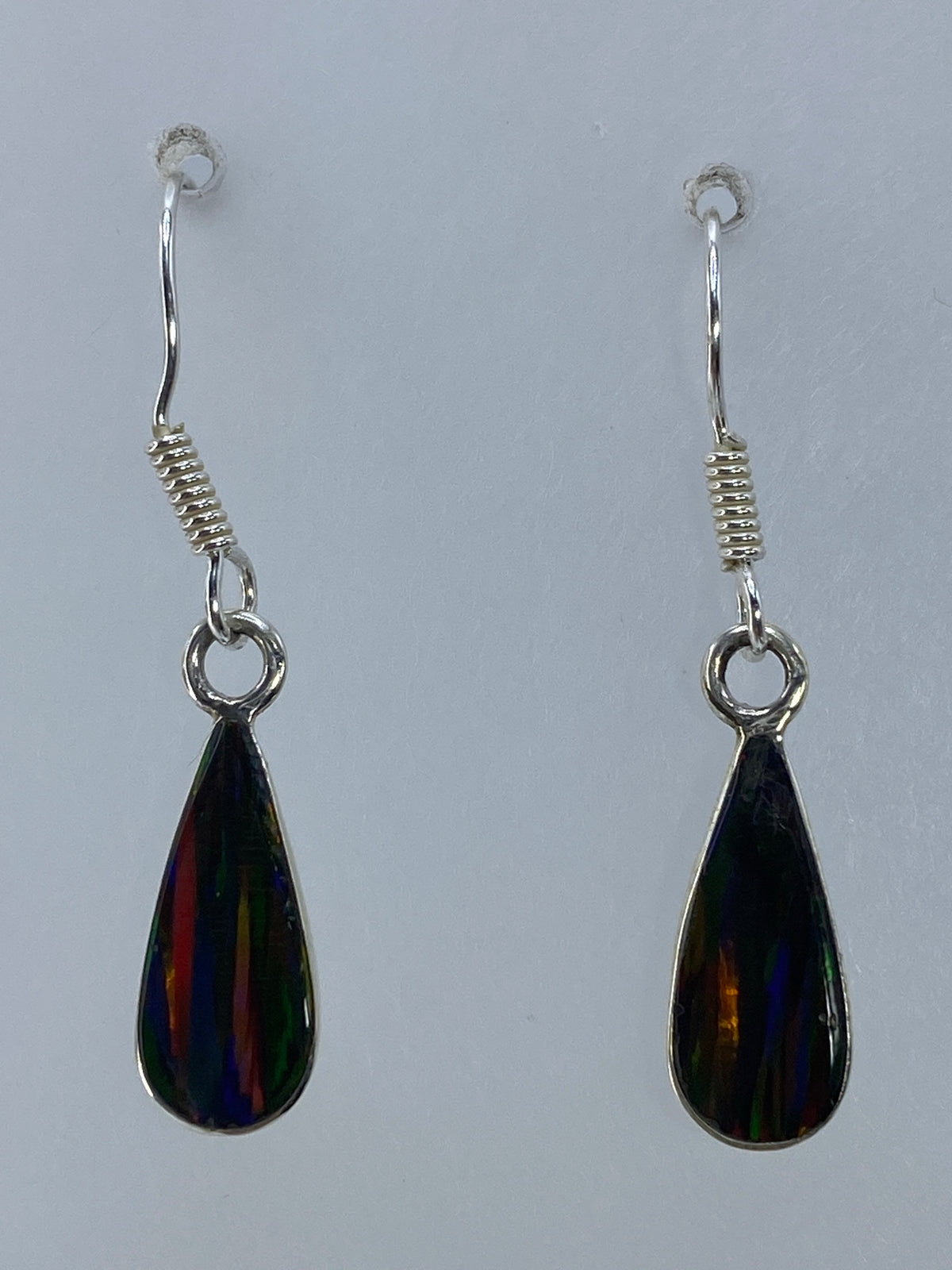 Par de aretes de plata con ópalo de Fuego multicolor colgando del gancho