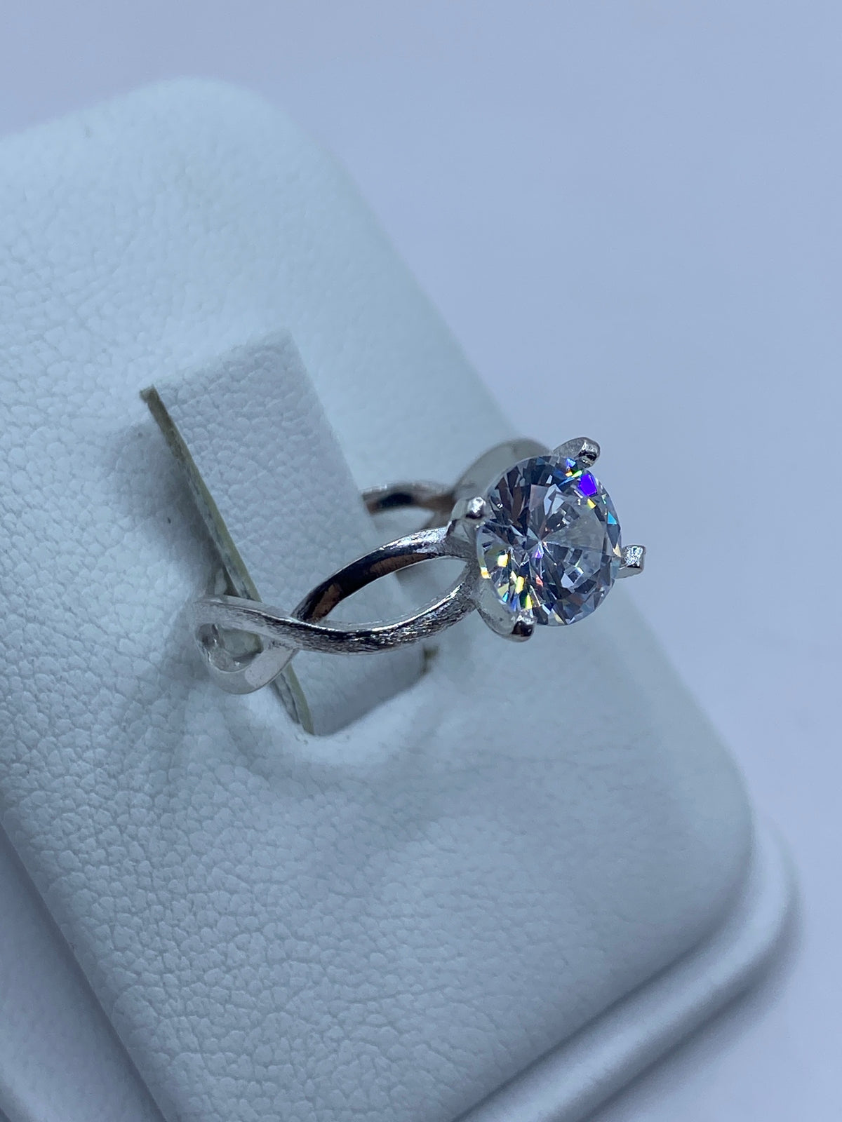 Vista frontal del anillo mostrando la circonia blanca engastada en prongs de plata