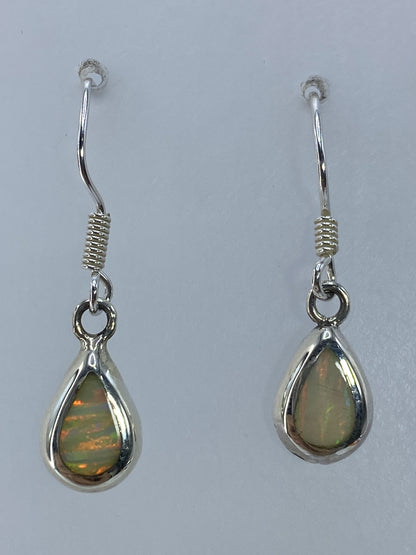 Ópalo de fuego multicolor en aretes de plata 950, detalle de los reflejos anaranjados y verdes