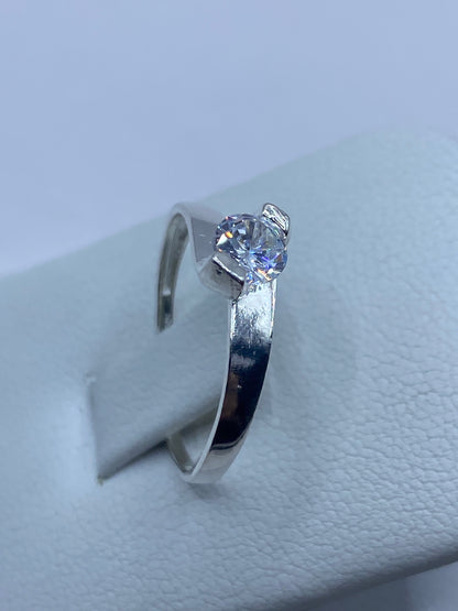 Anillo solitario de plata 925 puesto en un dedo — destello de la circonia