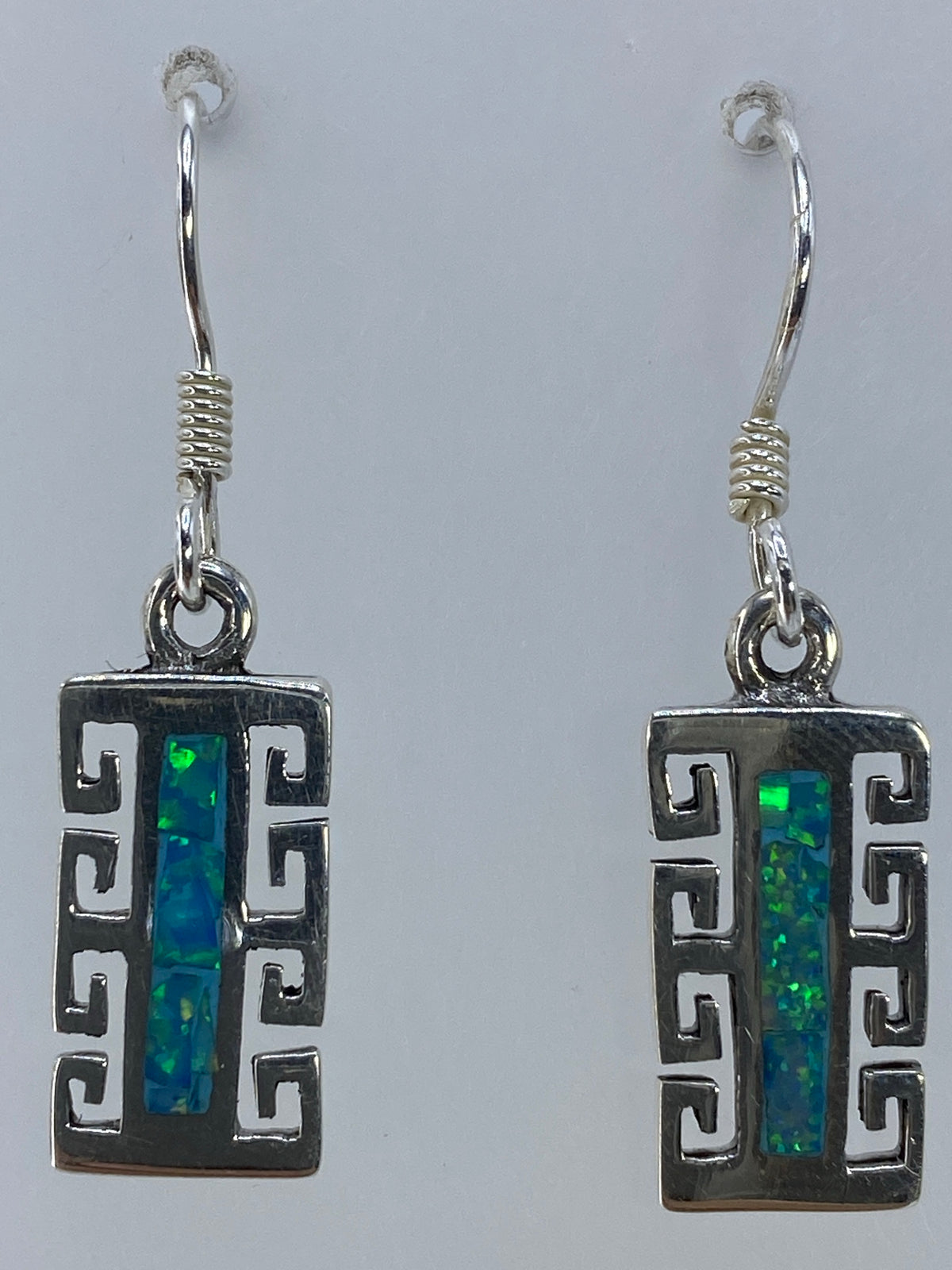 Aretes colgando mostrando el largo de 3.4 cm y el diseño geométrico