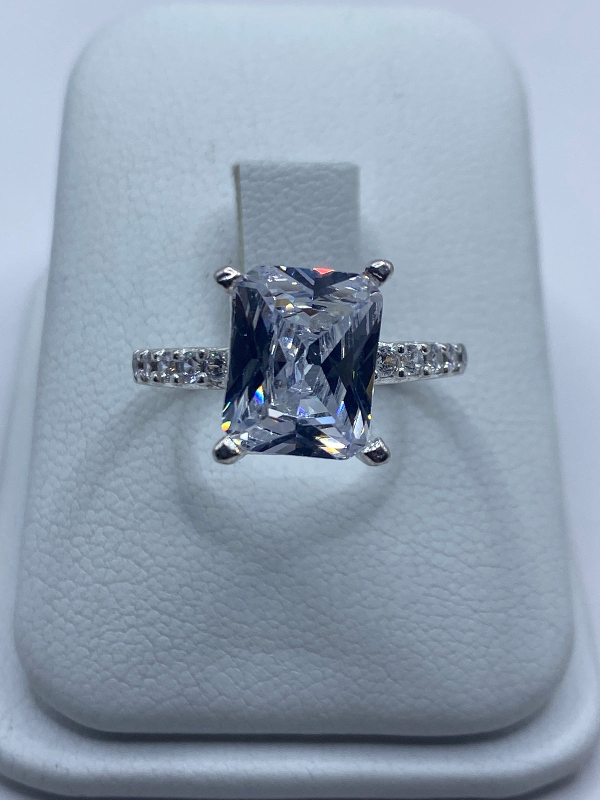Anillo de plata solitario con circonia blanca rectangular en dedo de mujer