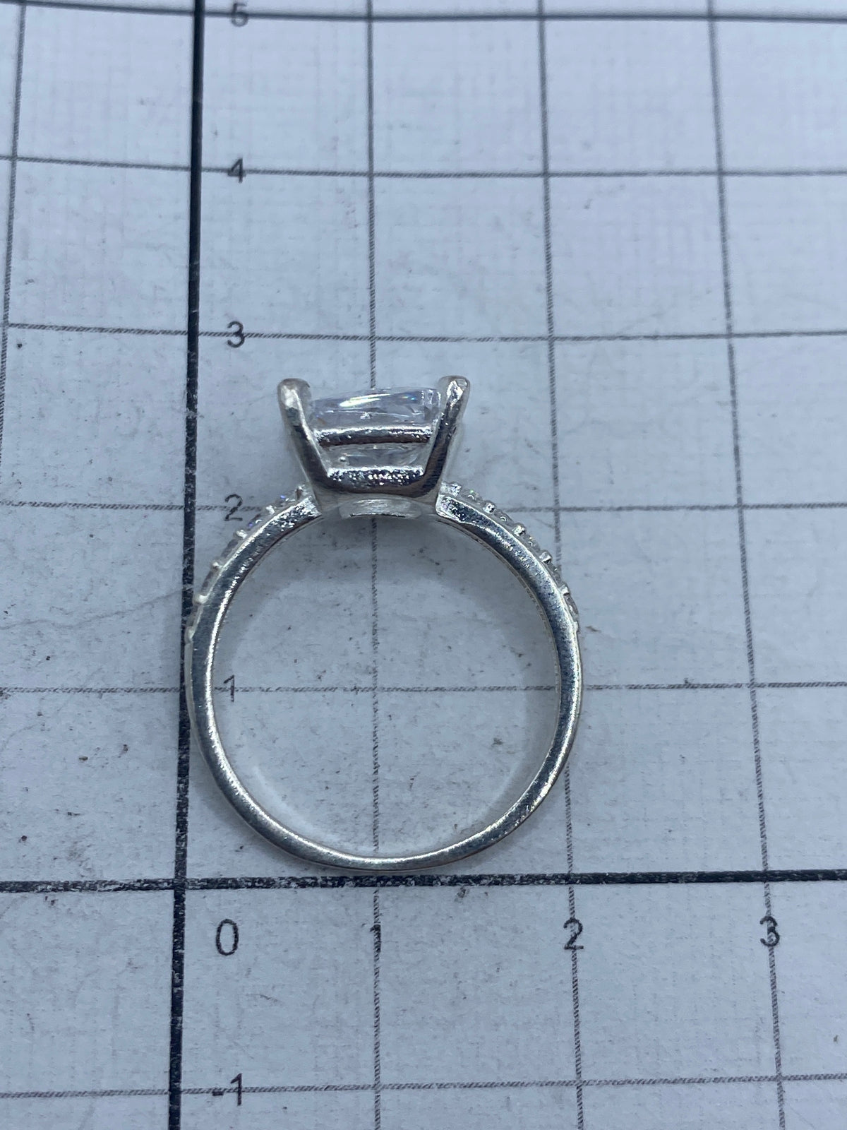 Anillo sobre fondo gris mostrando el brillo de la circonia blanca y el sello 925