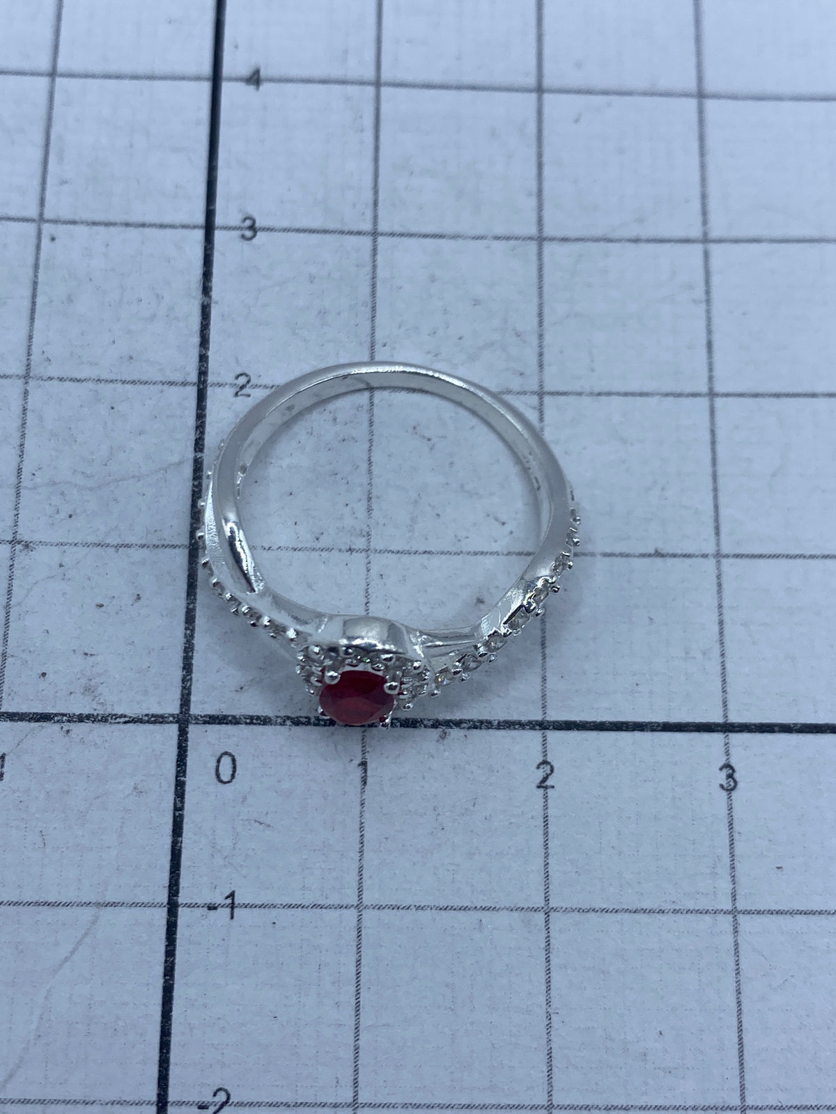 Anillo en mano de mujer mostrando el brillo del rojo y los destellos blancos