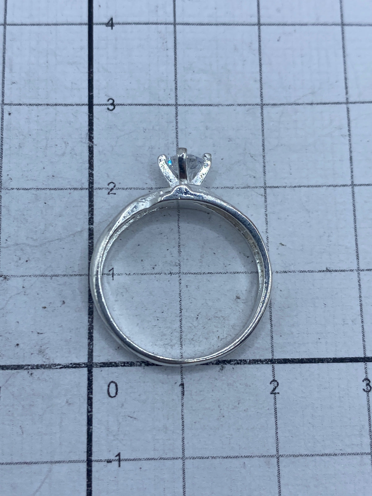 Anillo sobre fondo blanco mostrando el engaste a mano de la circonia