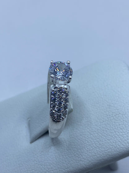 Anillo sobre fondo blanco mostrando el brillo de la circonia central