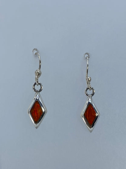 Detalle del arete de plata mostrando el engaste a mano del ópalo de fuego naranja