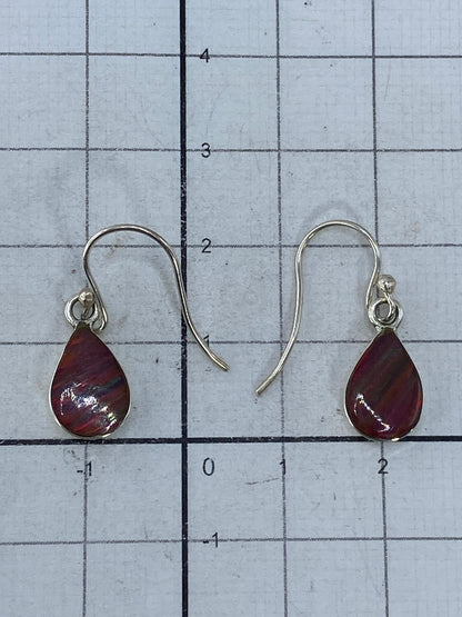 Aretes de ópalo de fuego sobre fondo blanco, capturando los reflejos del mineral