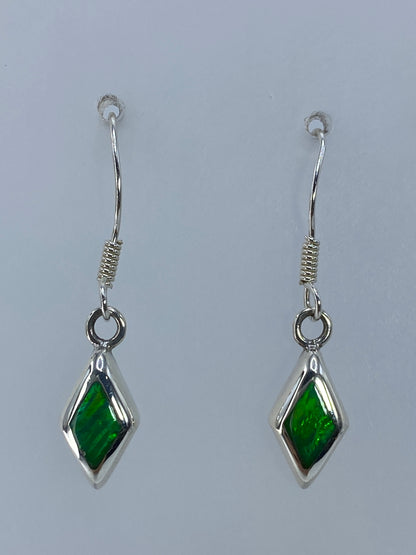 Detalle de los aretes mostrando el color verde limón y los destellos del ópalo
