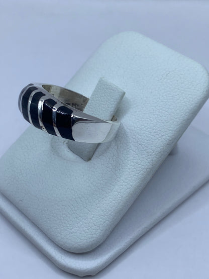 Anillo unisex de plata con ónix en la mano de una persona