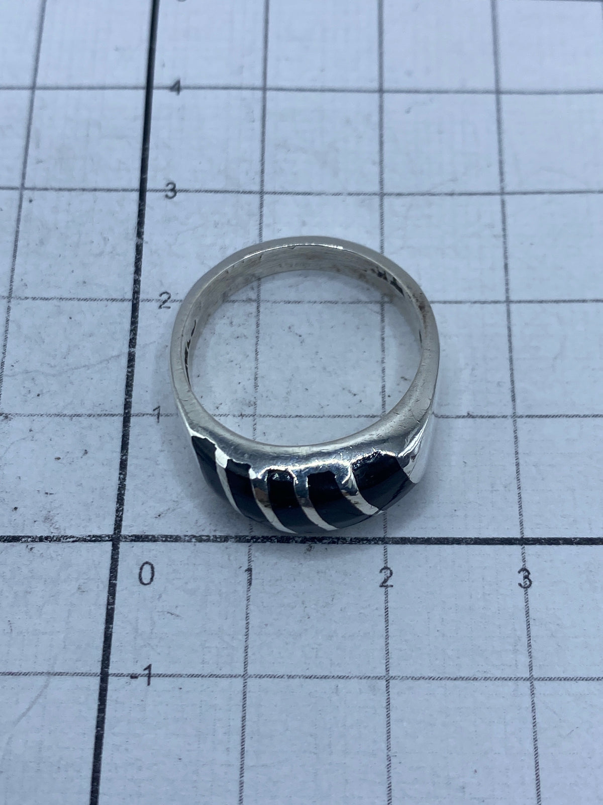 Anillo de ónix y plata mostrando el Quinto 925 en la banda interior
