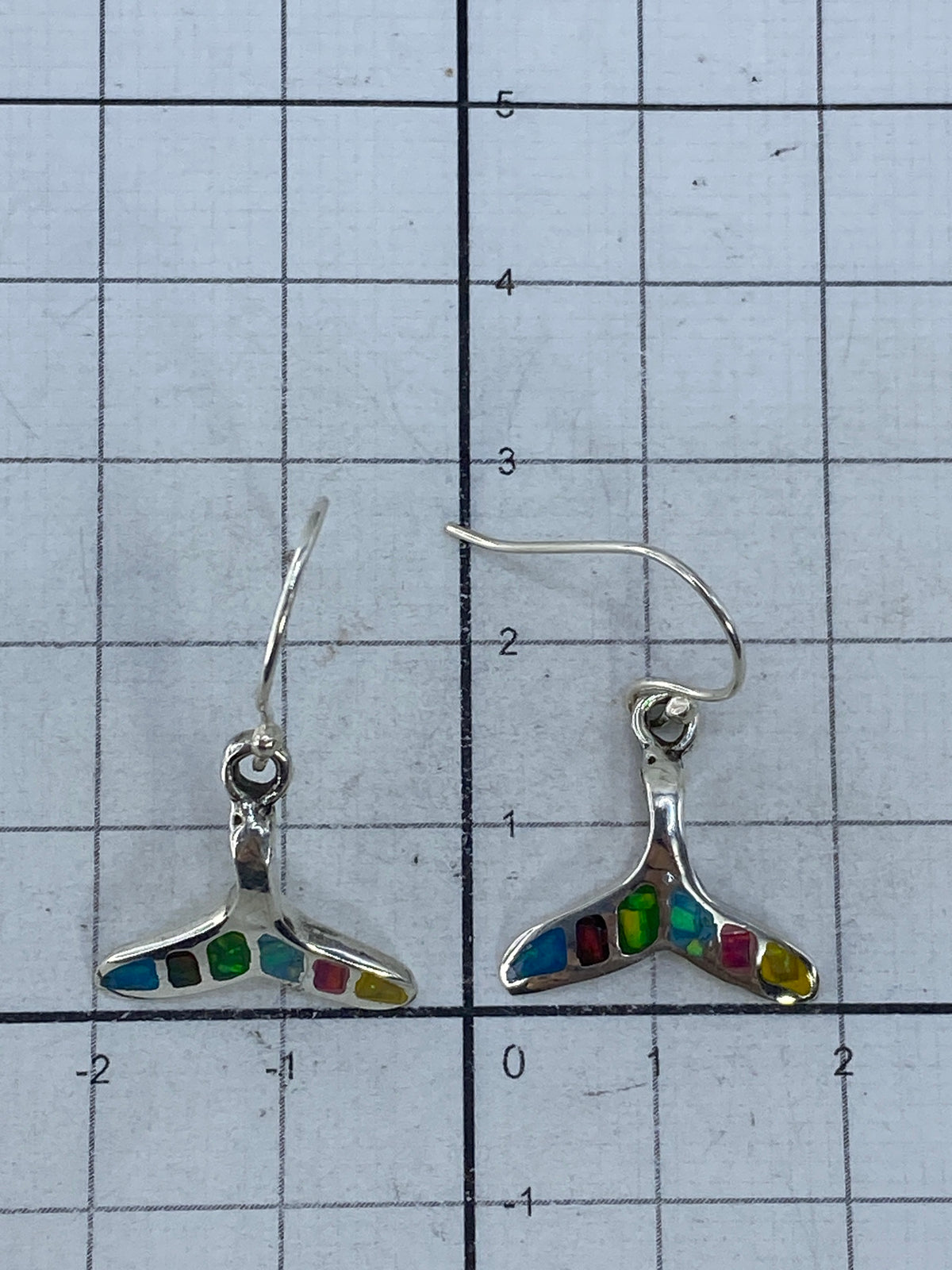 Aretes sobre escala midiendo 2.8 cm de largo con marcación de Quinto 950