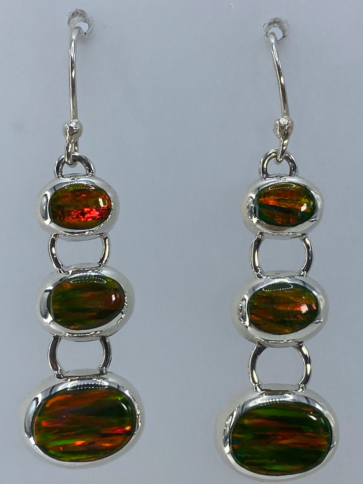 Detalle del engaste a mano y los reflejos de naranja y verde del ópalo
