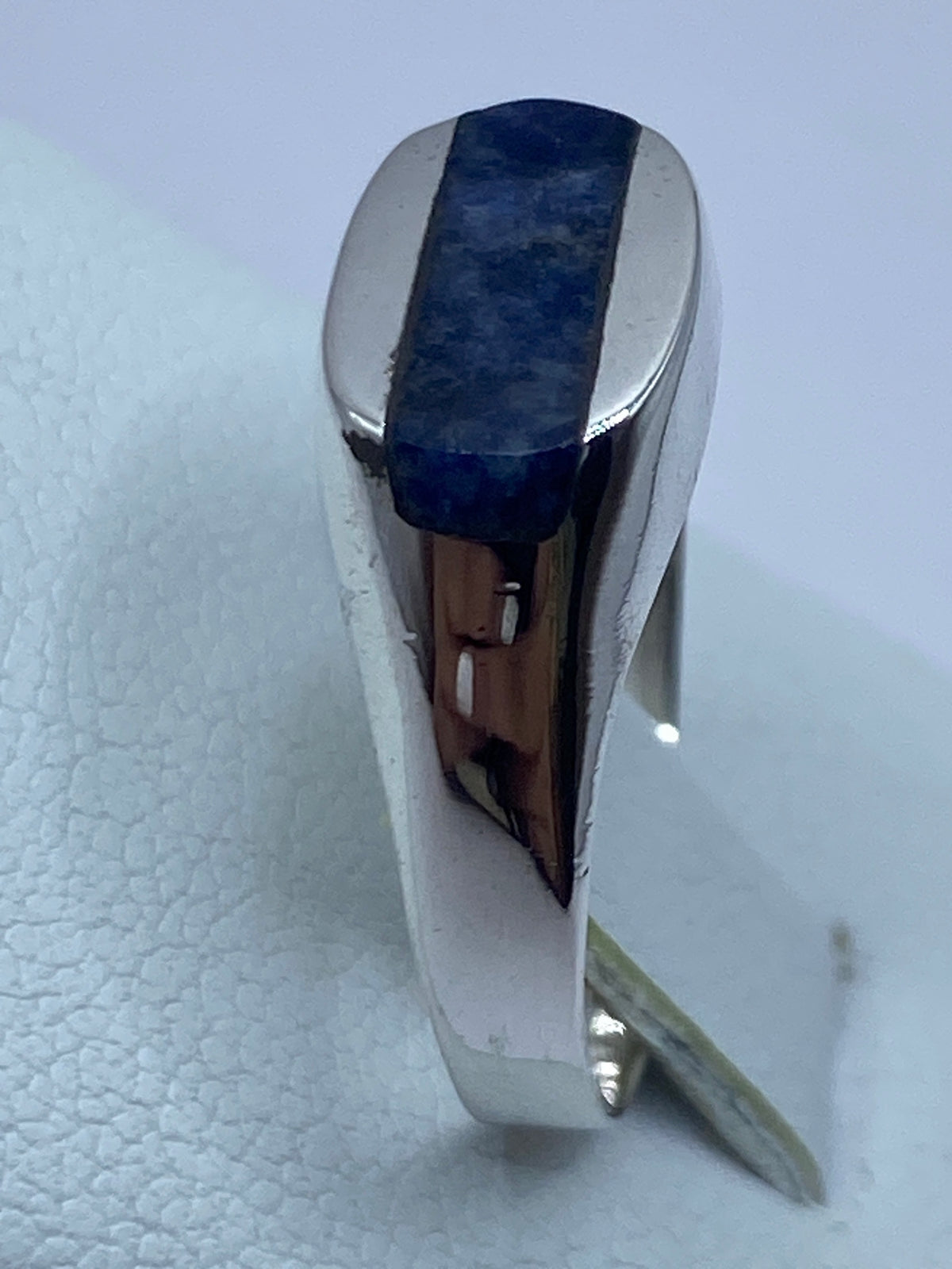 Anillo en el dedo de una mujer, luciendo la piedra azul y el brillo natural