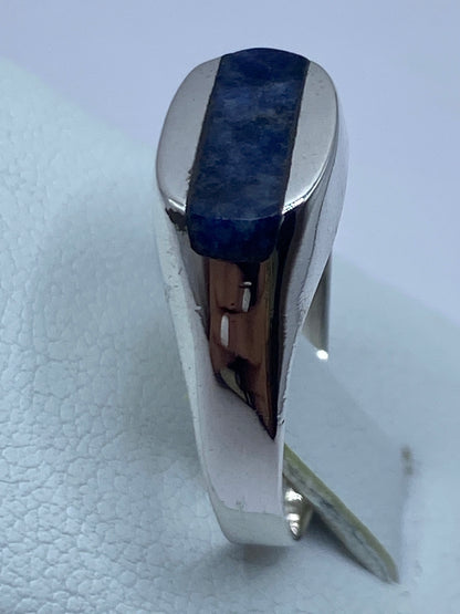 Anillo en el dedo de una mujer, luciendo la piedra azul y el brillo natural