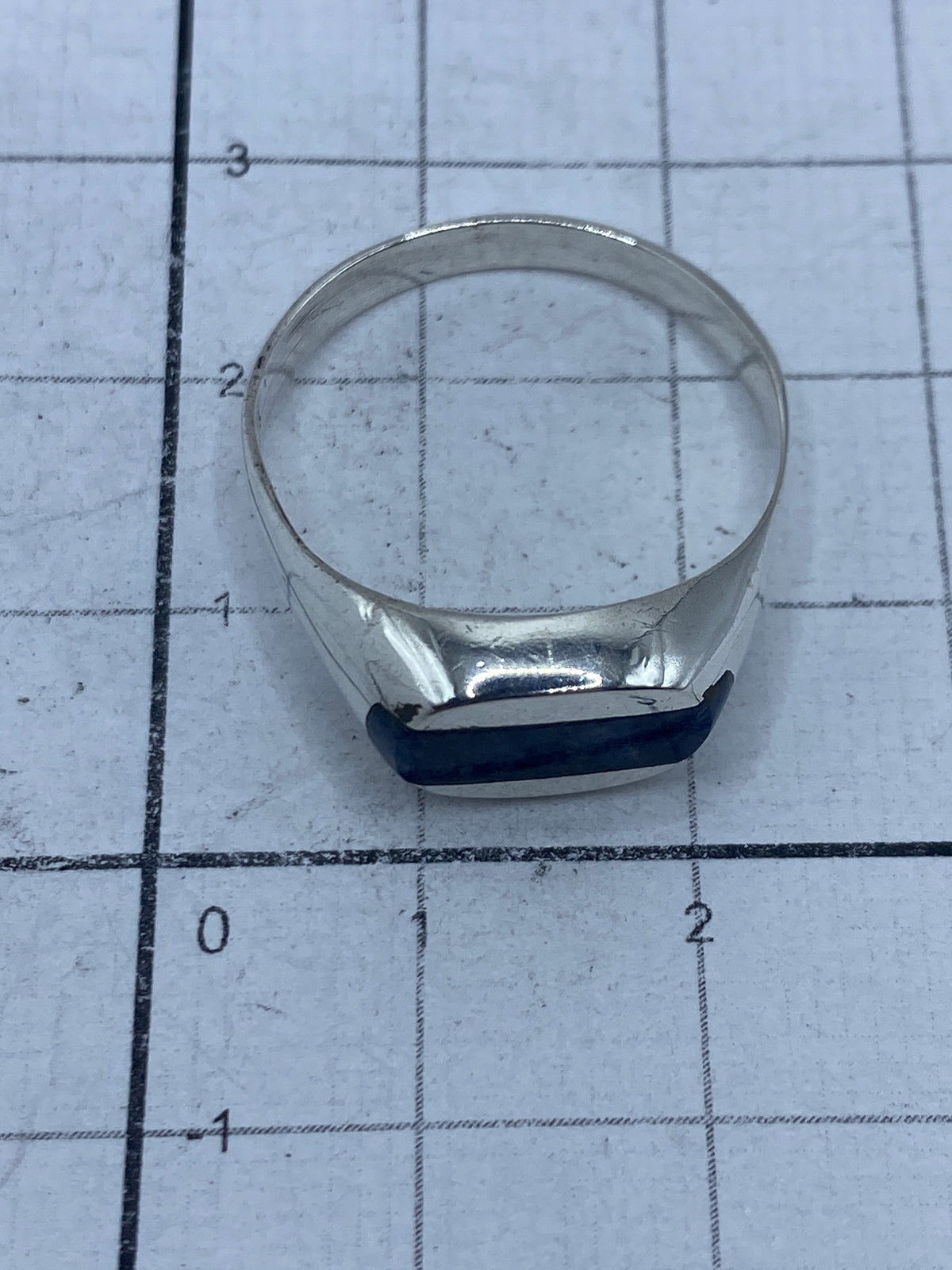 Anillo sobre fondo blanco con medidas de referencia, mostrando el Quinto 925