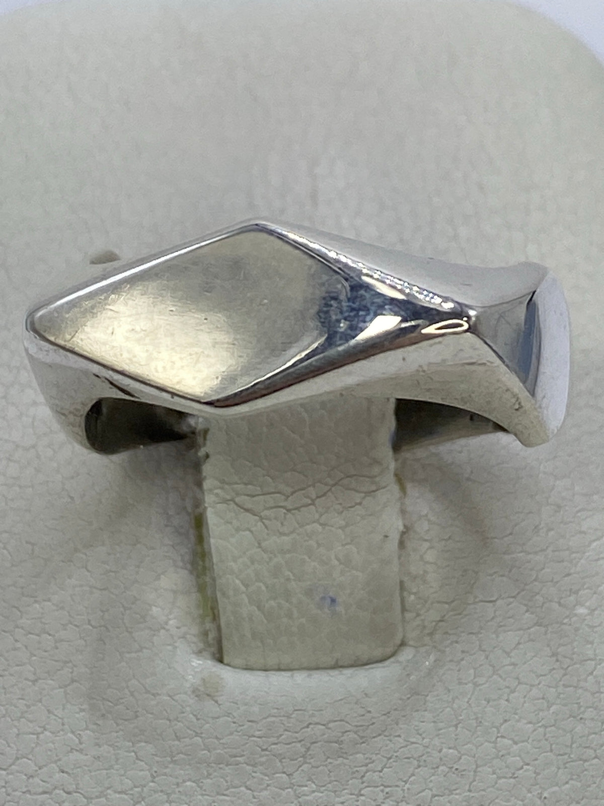 Anillo de plata repujado con relieve geométrico minimalista en mano masculina