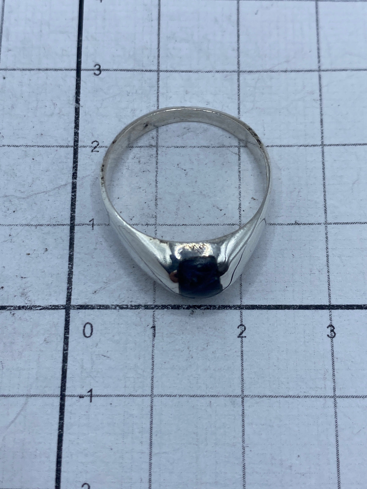 Anillo sobre superficie gris mostrando el Quinto 925 grabado