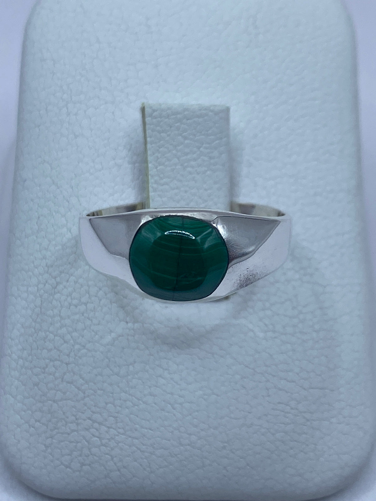 Anillo de plata 950 con malaquita verde engastada en la mano de una persona