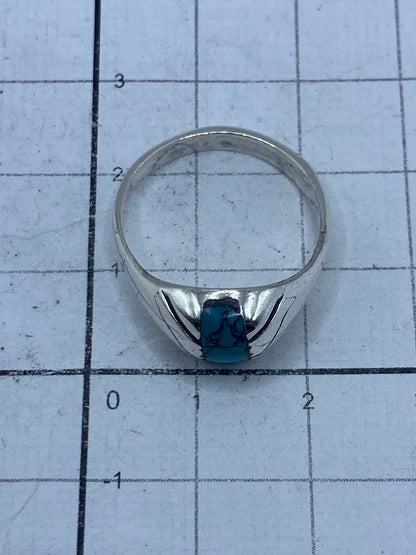 Anillo sobre fondo gris mostrando el acabado pulido de la plata y el azul profundo de la turquesa