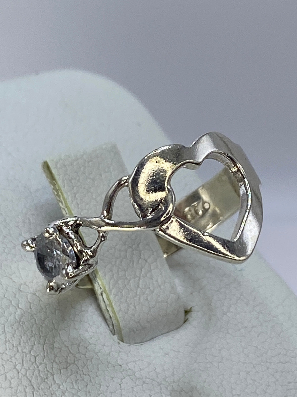 Vista lateral del anillo corazón de plata 925 en dedo de mujer