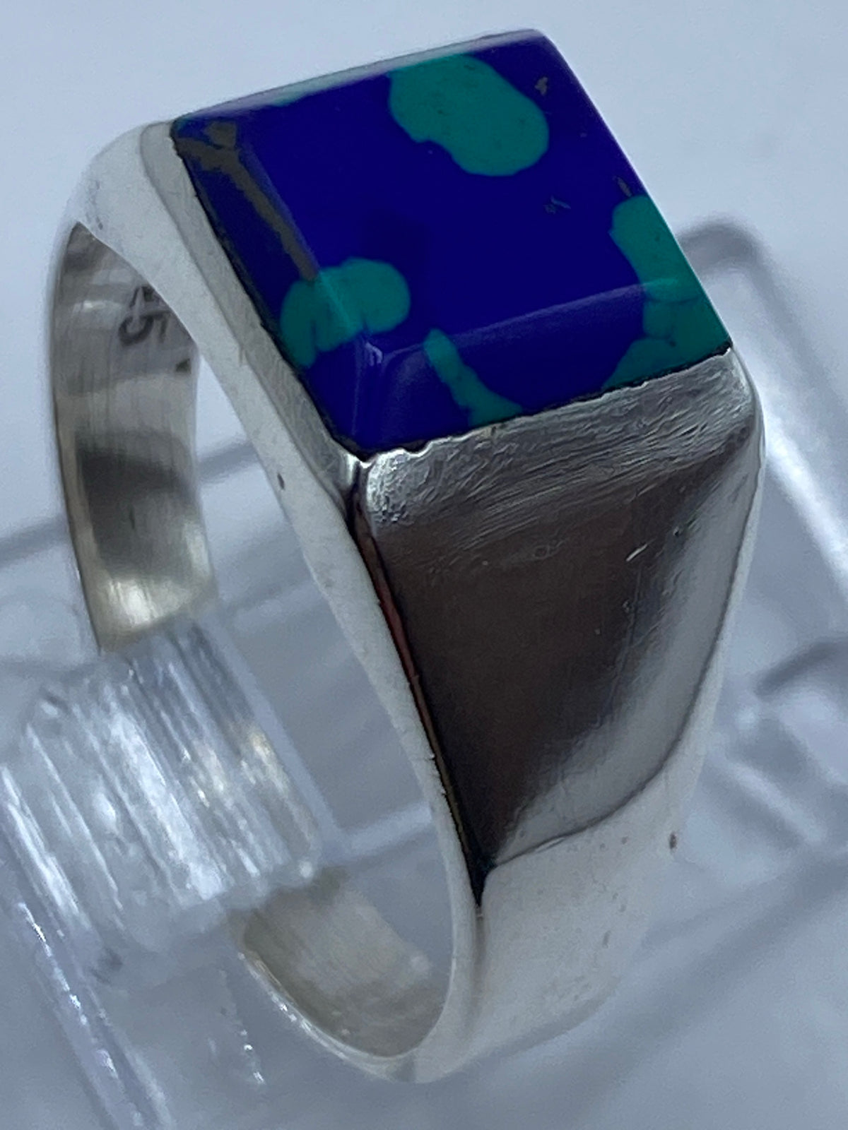 Detalle lateral del anillo de plata satinada con la piedra en su marco