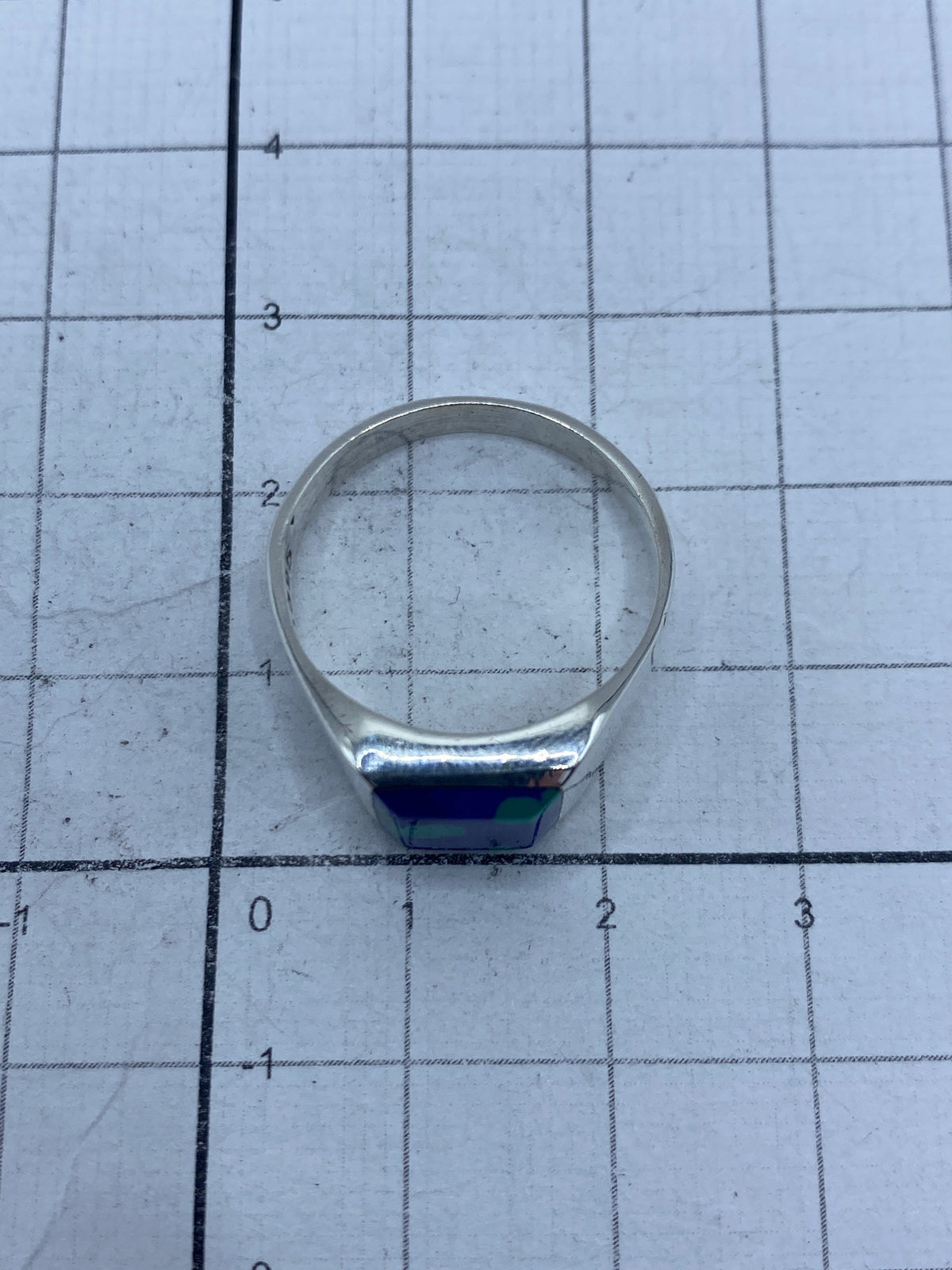 Anillo sobre fondo gris mostrando el peso y acabado de taller