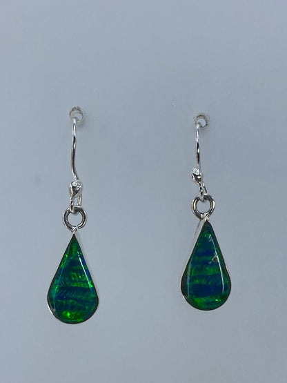 Aretes de plata con ópalo de fuego verde luminoso, detalle del engaste a mano y cierre de gancho