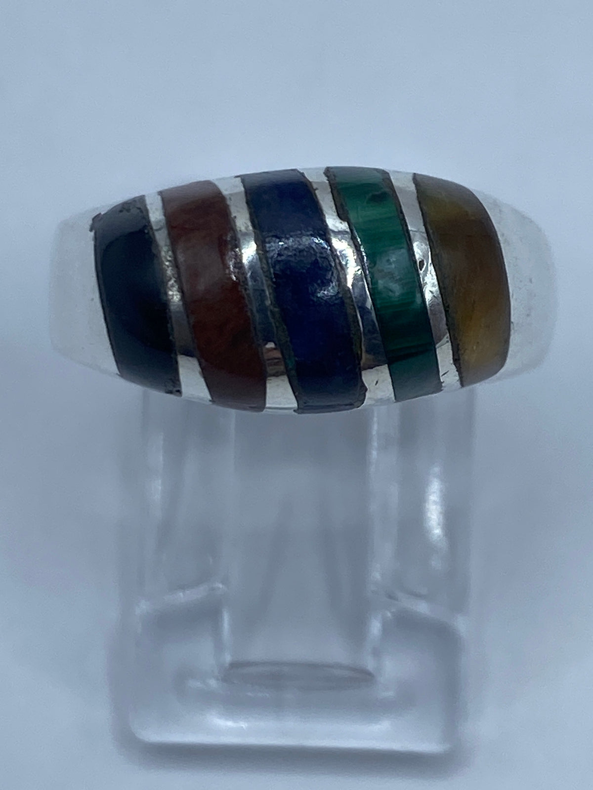Anillo de plata con cuatro piedras: malaquita verde, lapislázuli azul, ojo de gato café y ónix negra