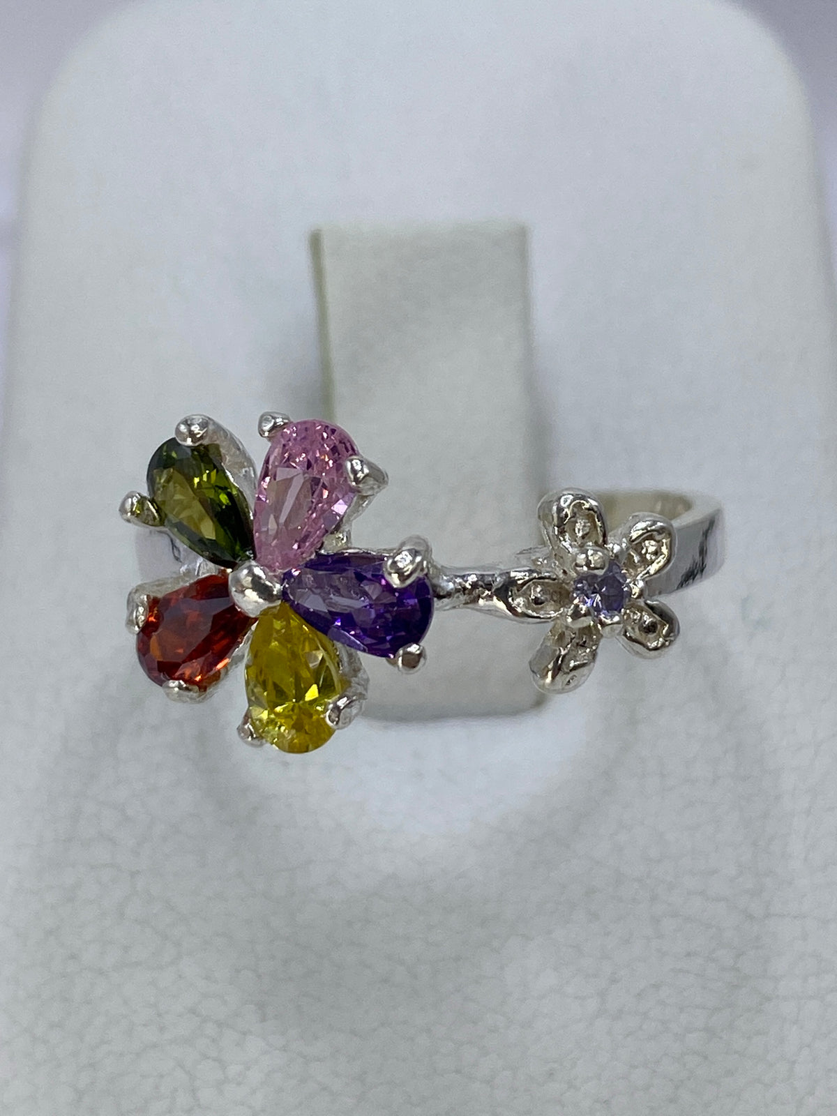 Anillo de plata 925 con circonia engastada en motivo floral, detalle del frente