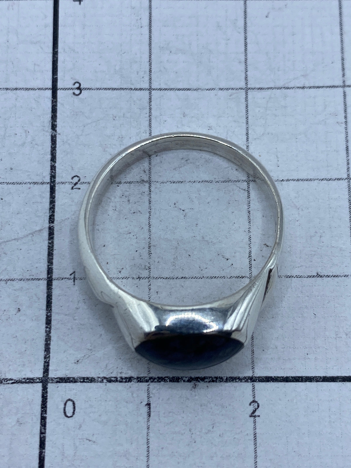 Anillo de plata sobre regla, mostrando el Quinto 925 grabado