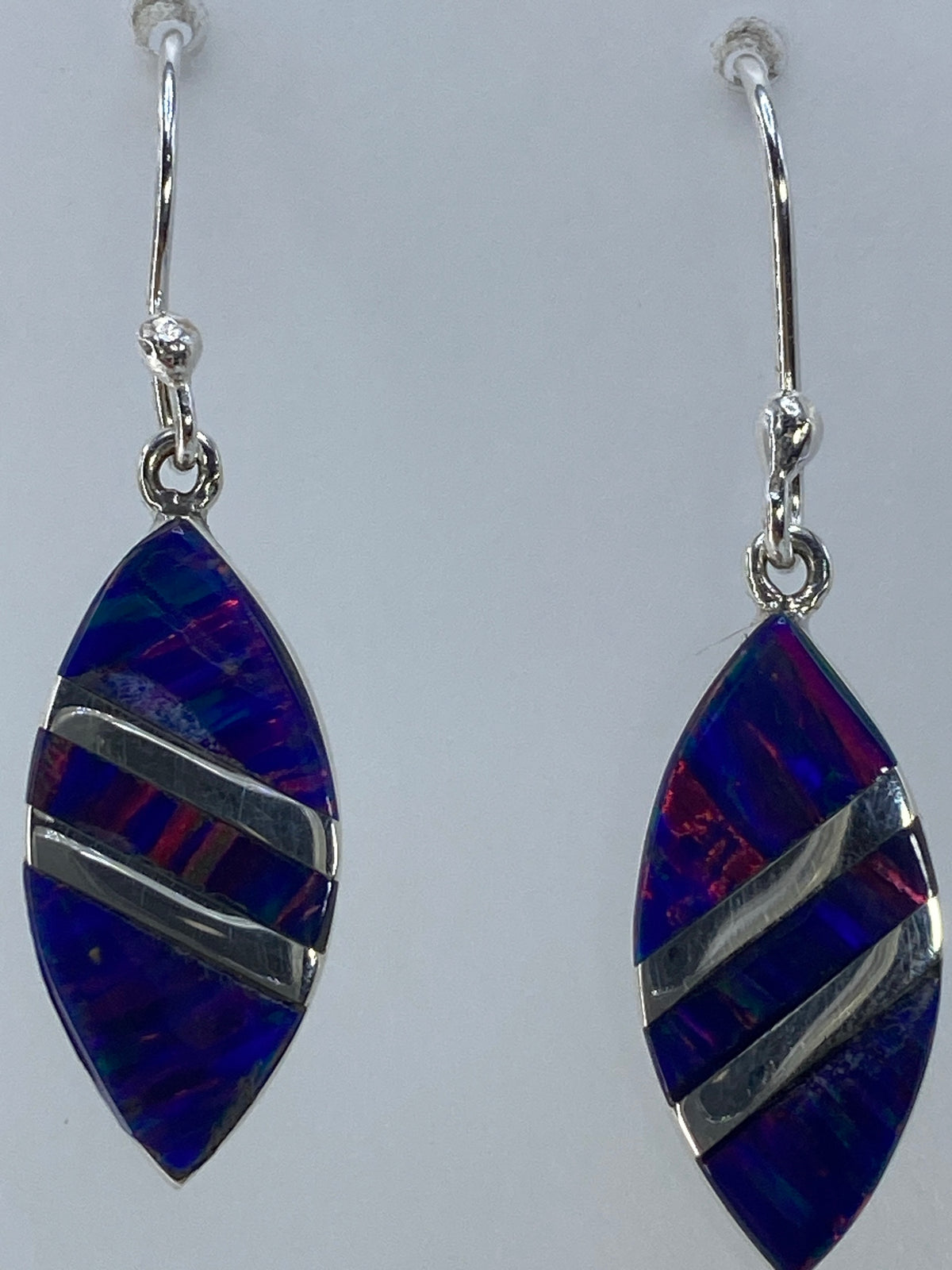 Aretes puestos mostrando el juego de colores del opalo