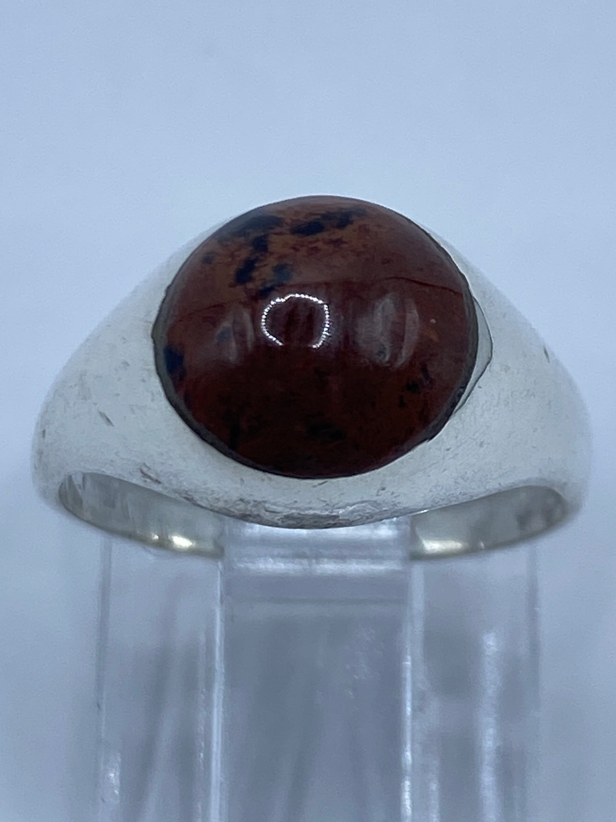 Anillo en la mano mostrando como se ve puesto, piedra cafe oscura
