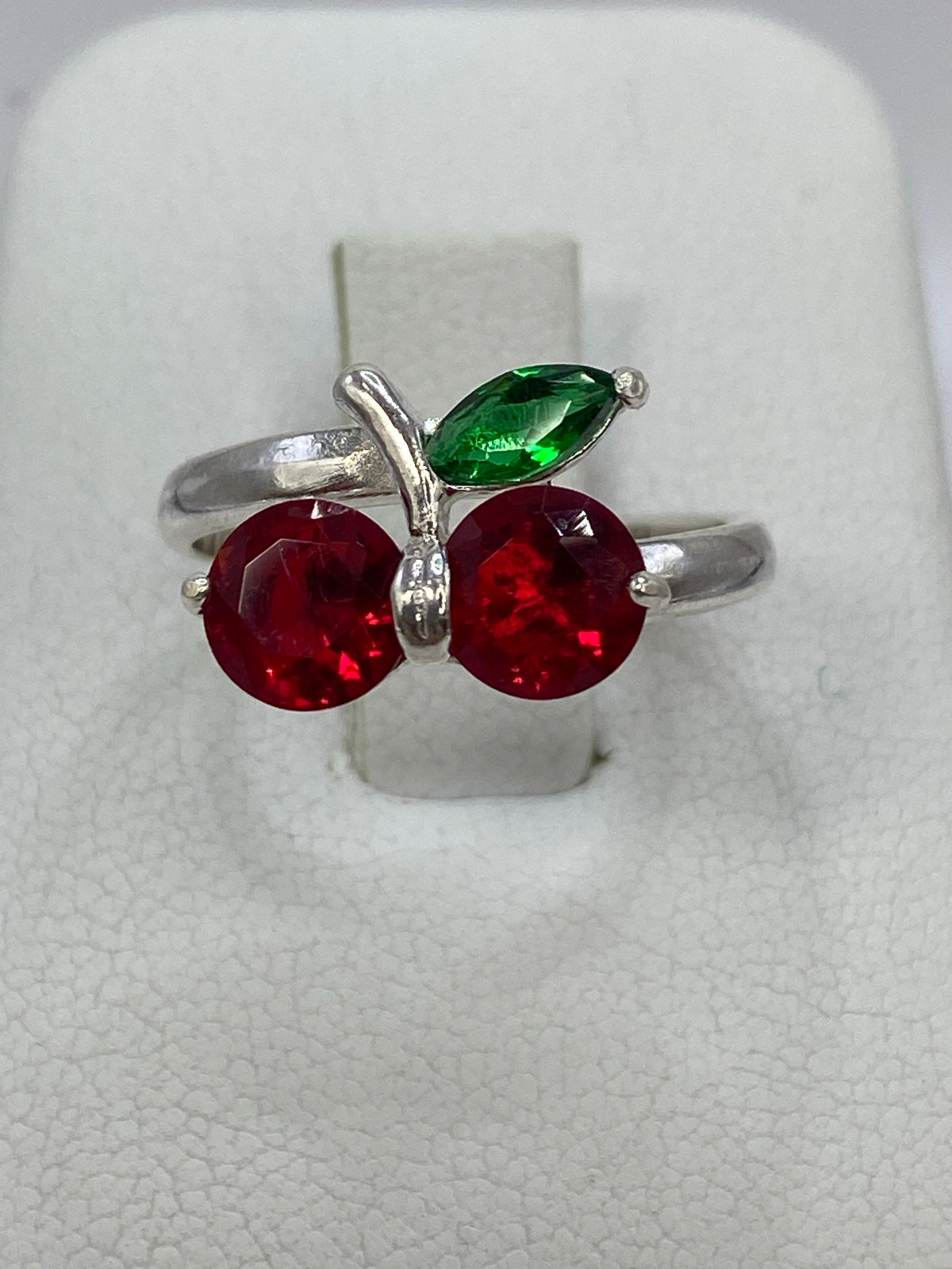 Anillo de plata 925 con dos circonia rojas brillantes en forma de cereza sobre fondo blanco