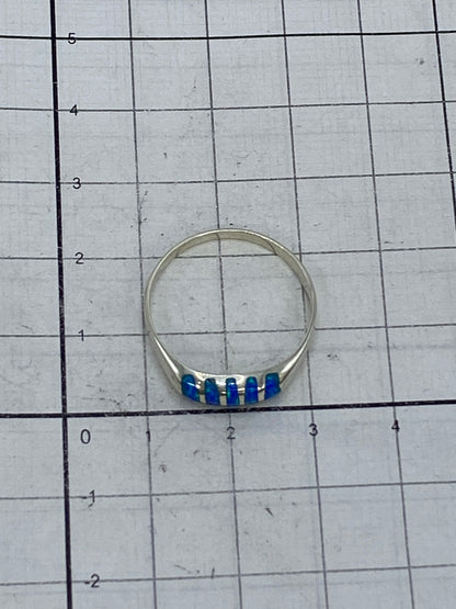 Anillo de plata ligero sobre fondo blanco con ópalo de fuego visible