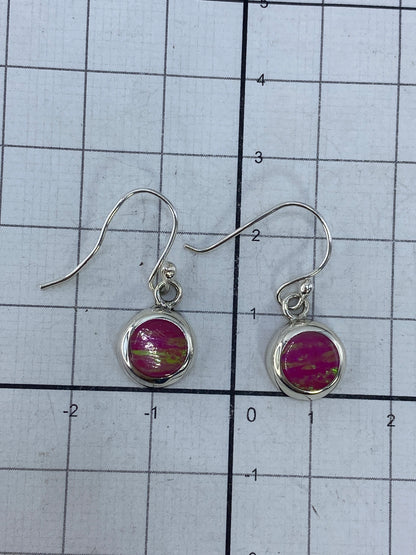 Aretes con ópalo de fuego en la mano, luciendo el color verde bosque