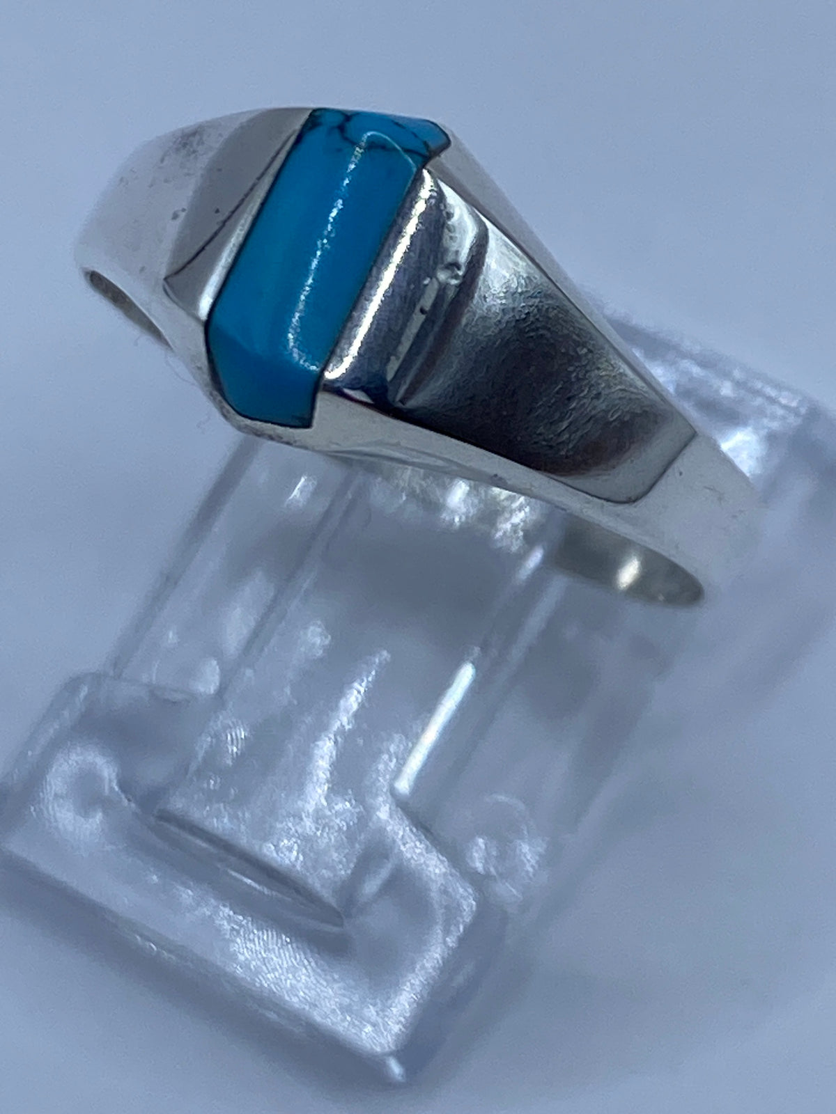 Detalle lateral del anillo mostrando la turquesa y el acabado pulido de la plata