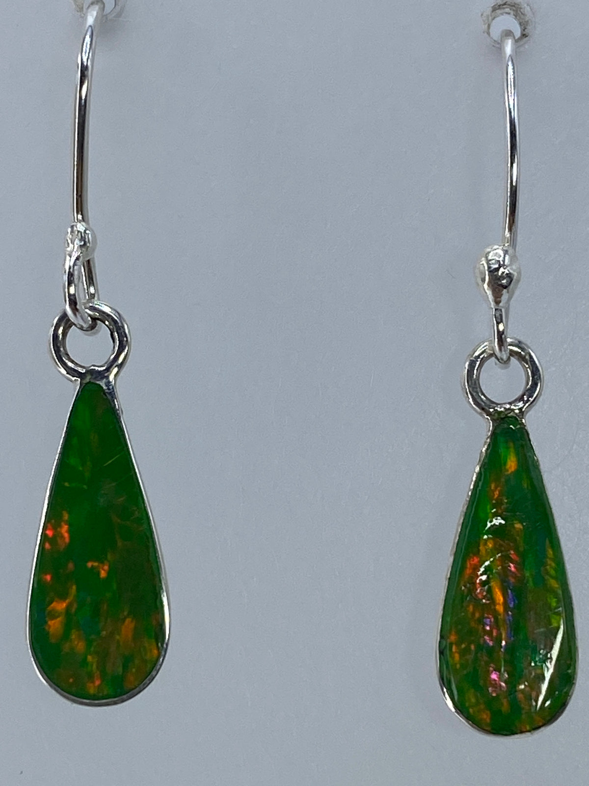 Aretes puestos, mostrando el movimiento y la luz del ópalo