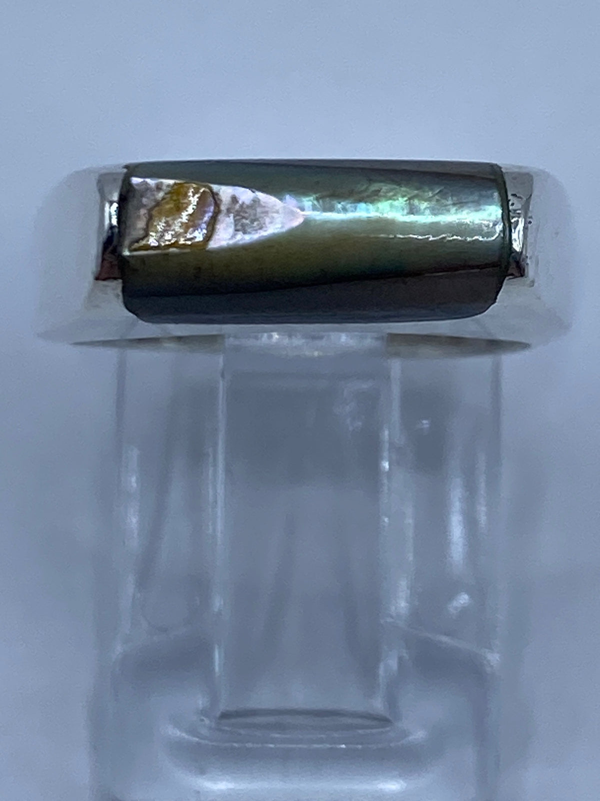 Anillo de plata con abulón puesto en la mano, vista lateral