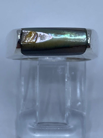 Anillo de plata con abulón puesto en la mano, vista lateral
