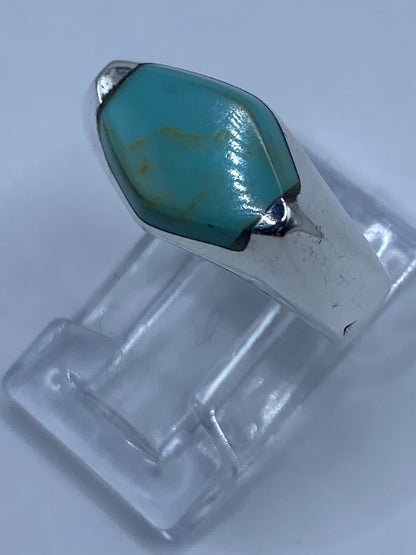 Anillo de turquesa sobre escala de centímetros mostrando el tamaño real de la piedra