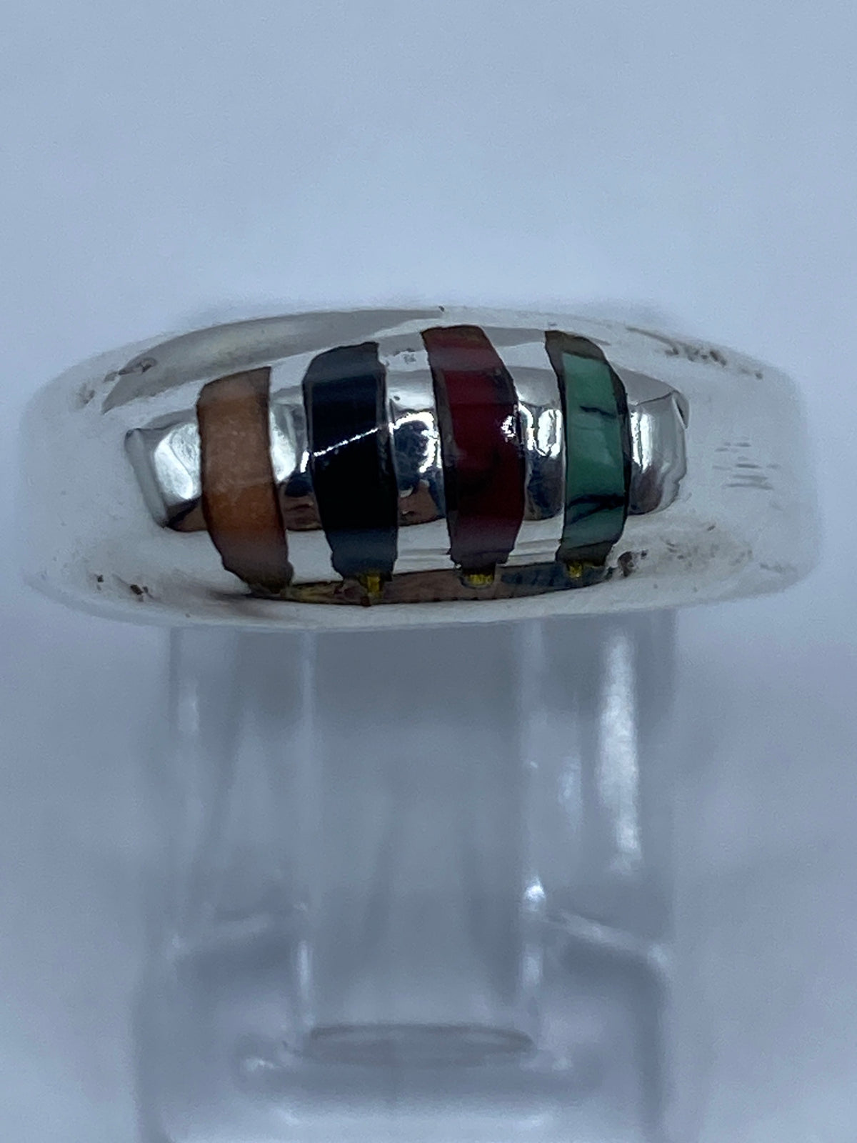 Detalle lateral del anillo con turquesa, coral y ónix en plata pulida