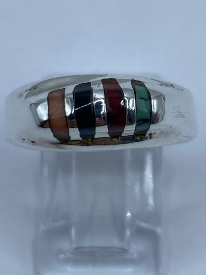 Detalle lateral del anillo con turquesa, coral y ónix en plata pulida