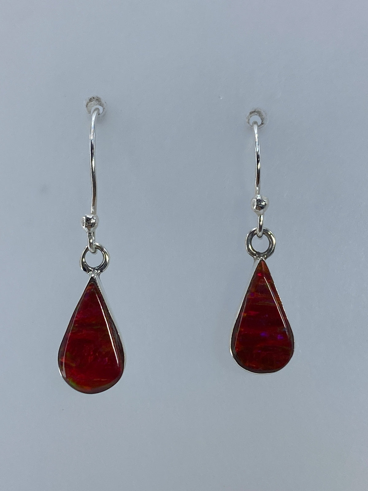 Detalle del ópalo de fuego rojo con brillo intenso en cada arete
