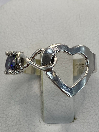 Anillo de plata 925 con circonia multicolor en solitario, sobre mano con fondo neutro