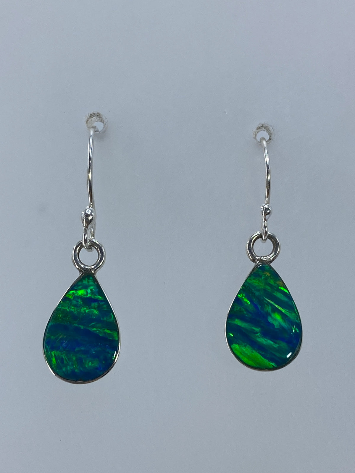 Par de aretes de plata 925 con opalo verde medidos en regla para mostrar los 2.7 cm de largo